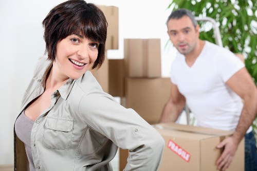 Mover wearing PPE while carrying household boxes